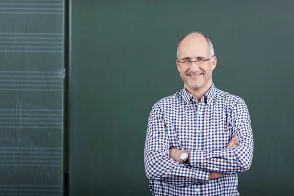 Professor With Arms Crossed Standing Against Chalkboard — Stock Photo, Image