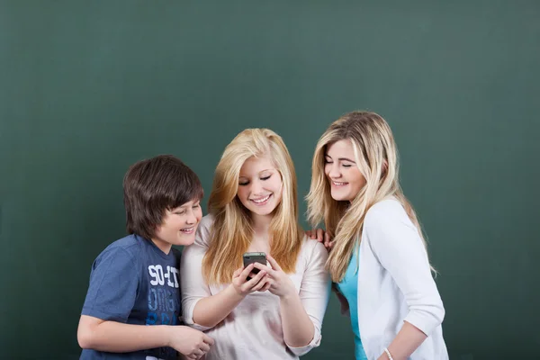 Estudante feminino compartilhando mensagens com amigos no celular — Fotografia de Stock