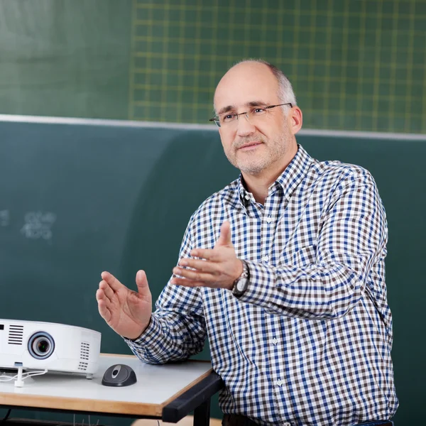 Professor mit Projektor und Maus gestikuliert im Hörsaal — Stockfoto