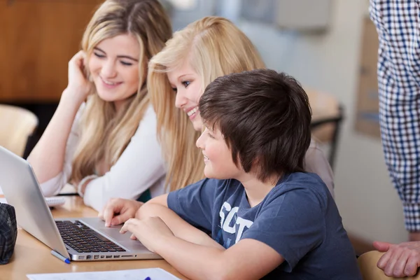 Estudiantes usando el ordenador portátil juntos en el escritorio — Foto de Stock