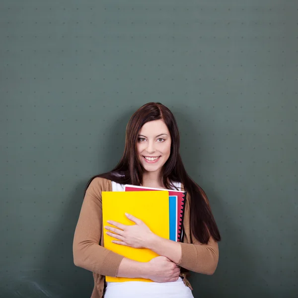 Vrouw met bestanden tegen schoolbord in klas — Stockfoto