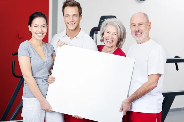 Groep fitness enthousiastelingen met een leeg bord — Stockfoto