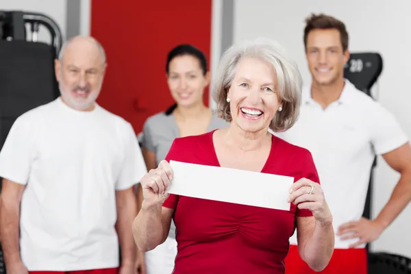 Happy senior woman holding a blank sign — Stock Photo, Image