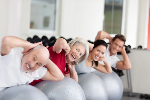 Smiling elderly woman training in a group — Stock Photo, Image