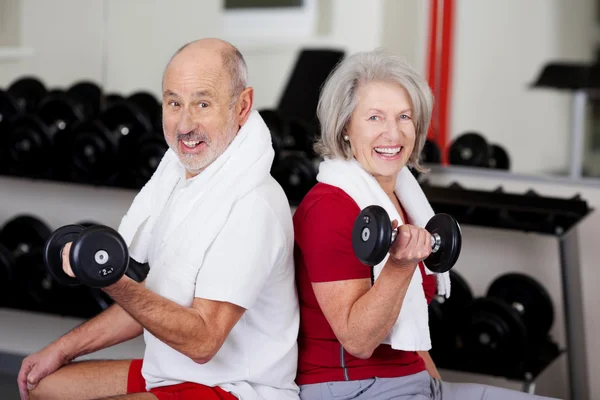 Senior Couple Lifting Dumbbells While Sitting In Gym — Stock Photo, Image