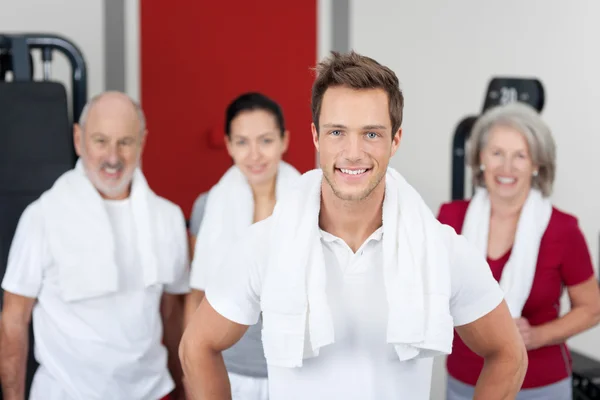 Jeune homme souriant avec la famille dans la salle de gym — Photo