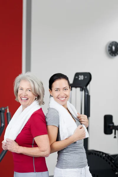 Mère et fille debout dos à dos dans la salle de gym — Photo