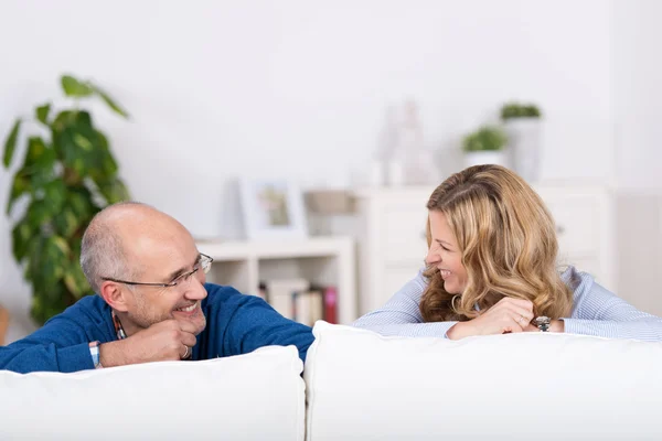 Ler lekfulla par avkopplande på en soffa — Stockfoto