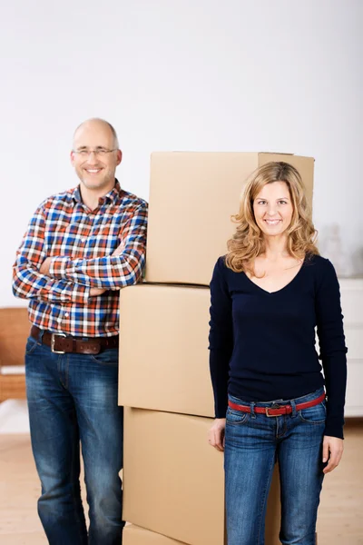 Couple standing with boxes in their new house — Stock Photo, Image