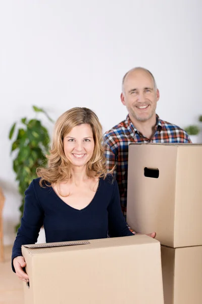 Casal transportando caixas de papelão na nova casa — Fotografia de Stock