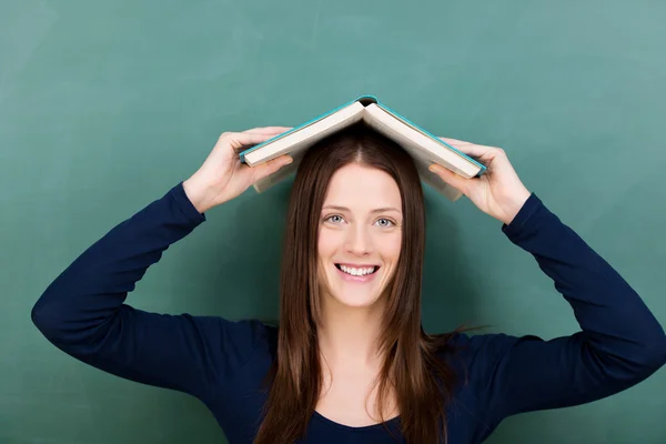 Pretty young female student carrying a book — Stock Photo, Image