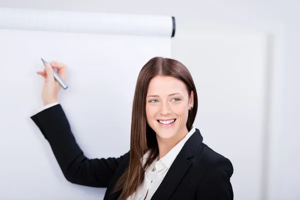 Attractive businesswoman writing on — Stock Photo, Image