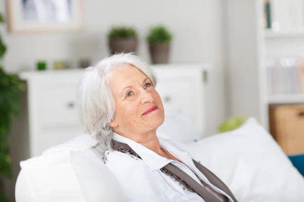 Daydreaming smiling elderly woman — Stock Photo, Image