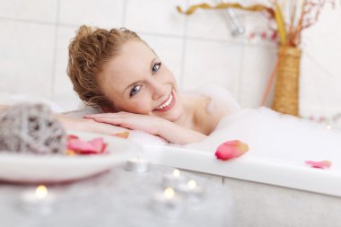 Beautiful woman relaxing in a foam bath clipart