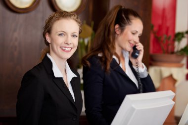 Two women working as professional receptionists clipart