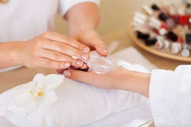 Woman having a manicure and massage clipart