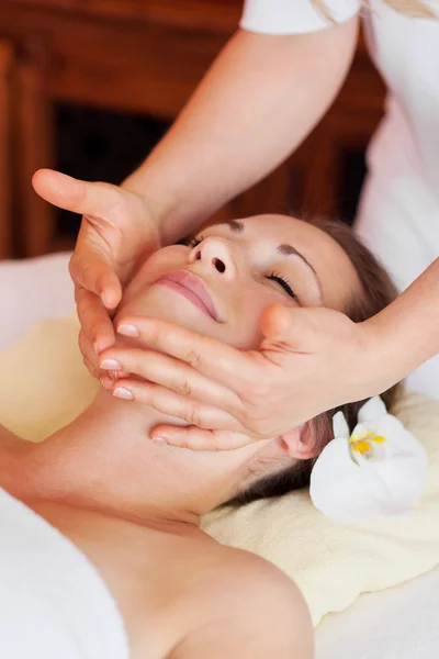Jovem bela mulher recebendo uma massagem facial — Fotografia de Stock