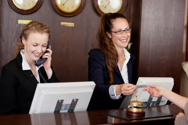 Two receptionists at a reception desk — Stock Photo, Image