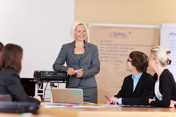 Leende affärskvinna ger en presentation — Stockfoto