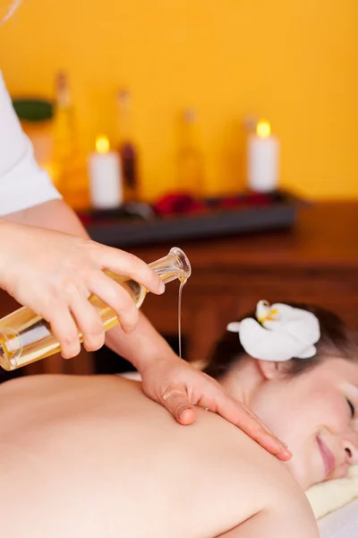 Mulher feliz recebendo uma massagem com óleo aromático — Fotografia de Stock