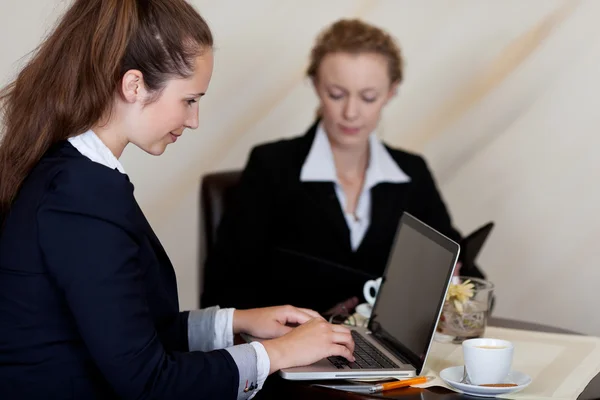 Two businesswomen working in a hotel lobby — Stock Photo, Image