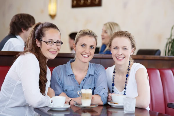 Három fiatal női barátaim élvez egy csésze-ból kávéház — Stock Fotó