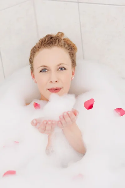 Hravé žena fouká bubblebath pěna — Stock fotografie