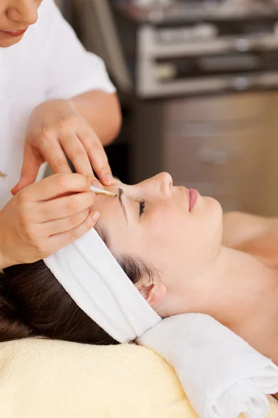 Esteticista arrancando umas sobrancelhas de mulher — Fotografia de Stock