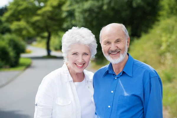Elderly couple standing in a rural road — Stock Photo, Image