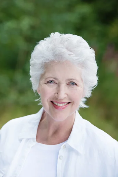 Beautiful senior lady outdoors in the park — Stock Photo, Image