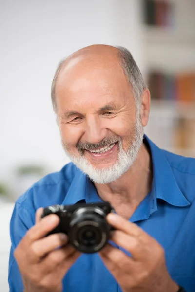 Smiling senior man with a camera — Stock Photo, Image