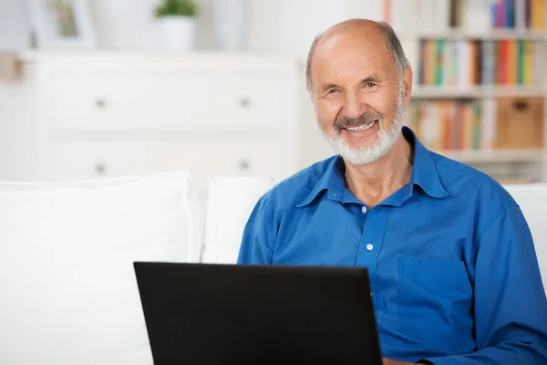 Uomo anziano sicuro di sé utilizzando un computer portatile — Foto Stock