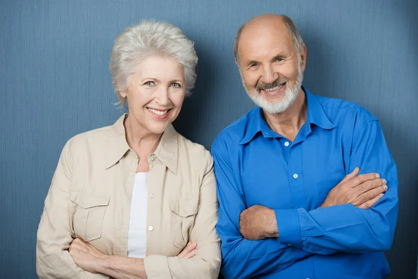 Vertrouwen bejaarde echtpaar met gevouwen armen — Stockfoto