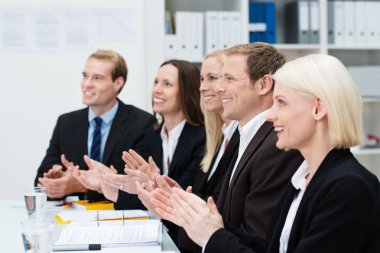 Smiling business people clapping their hands clipart