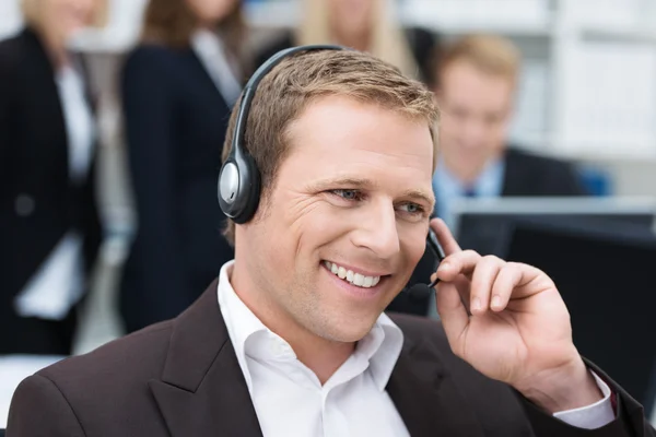 Businessman taking a call on a headset — Stock Photo, Image