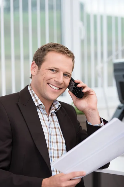 Przyjazny biznesmen mówić na jego telefon komórkowy — Zdjęcie stockowe