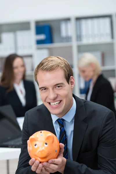 Successful businessman holding a piggy bank — Stock Photo, Image
