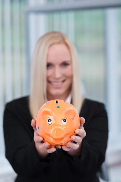 Blonde zakenvrouw met een piggy bank — Stockfoto