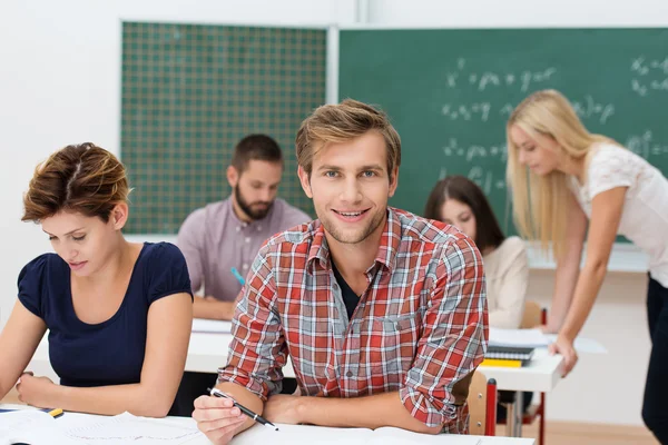 Lachende jonge man aan hogeschool of Universiteit — Stockfoto