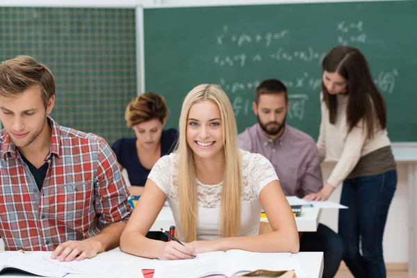 Beautiful happy young woman in class — Stock Photo, Image