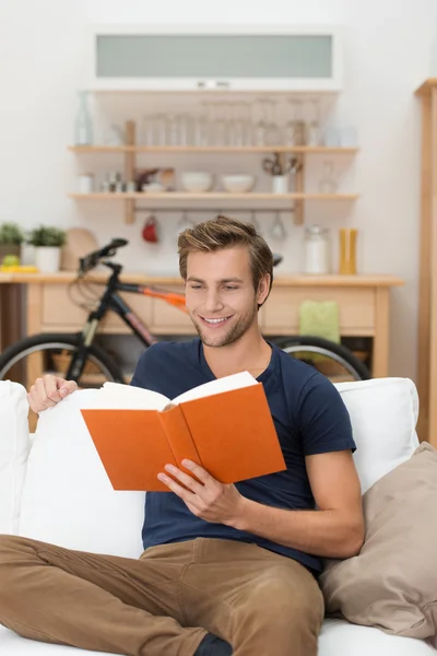 Jeune homme relaxant lisant un livre — Photo