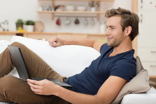 Young man relaxing with a laptop computer — Stock Photo, Image