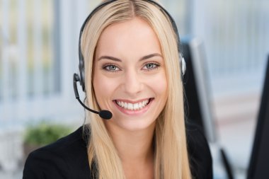 Smiling woman wearing a headset clipart