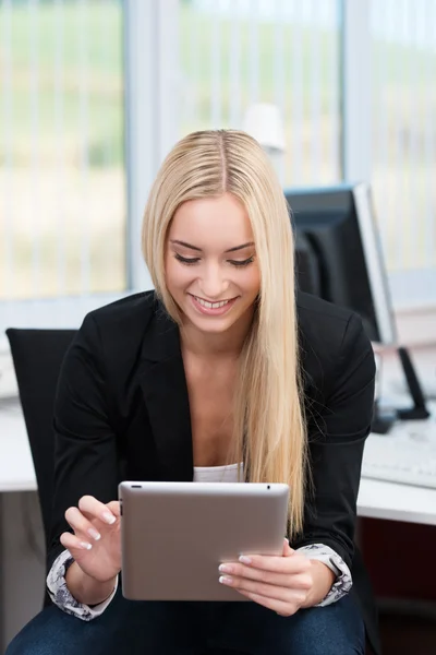 Jeune femme travaillant sur une tablette au bureau — Photo