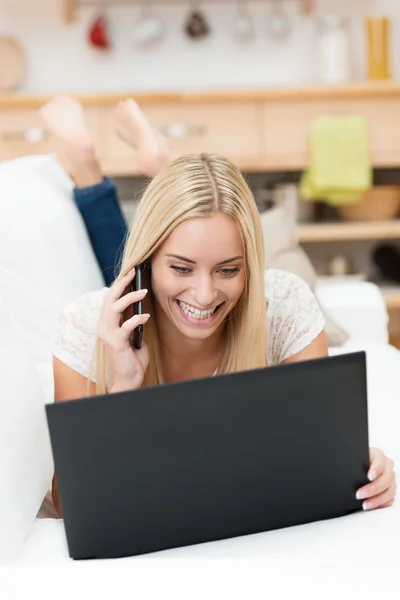 Fröhliche junge Frau plaudert auf ihrem Handy — Stockfoto