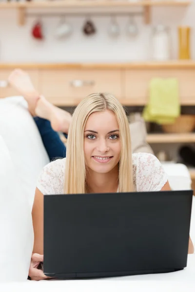 Junge Frau entspannt zu Hause mit ihrem Laptop — Stockfoto