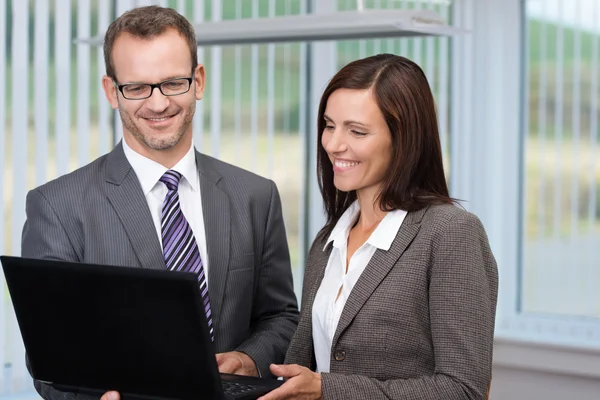 Business man and woman using a laptop — Stock Photo, Image