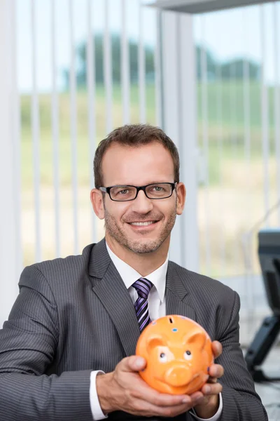 Businessman holding a piggy bank — Stock Photo, Image