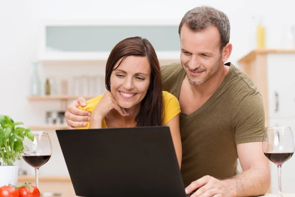 Vonzó pár használ egy laptop, a konyhában — Stock Fotó