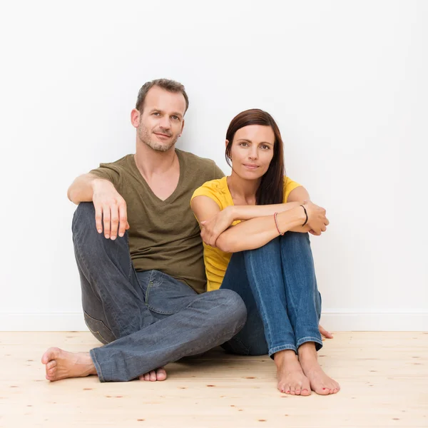Atraente jovem casal sentado no chão — Fotografia de Stock